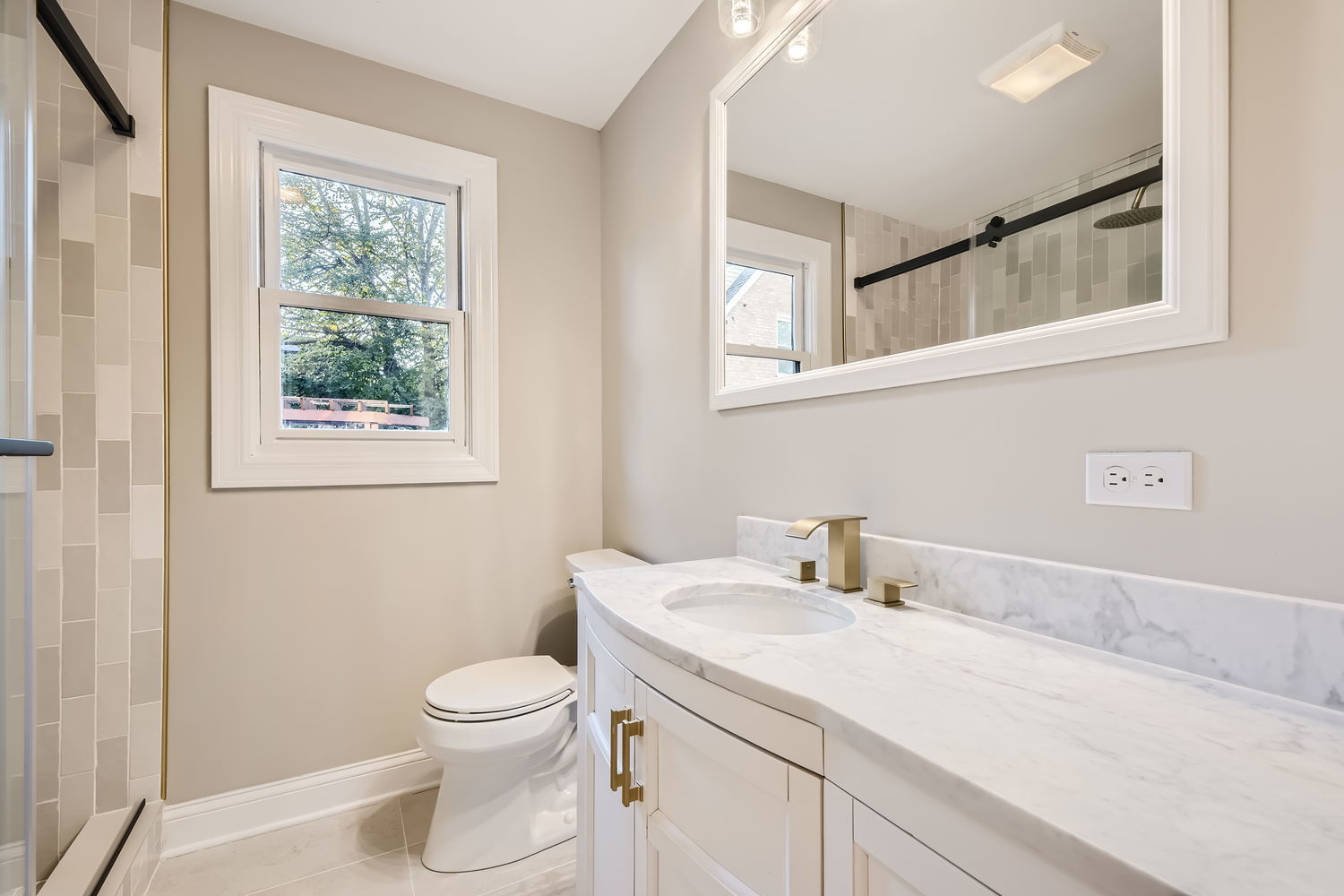 386 Blackhawk Road Riverside, IL 60546 - Photo 16 of 44 a bathroom with a granite countertop toilet a sink a mirror and a window