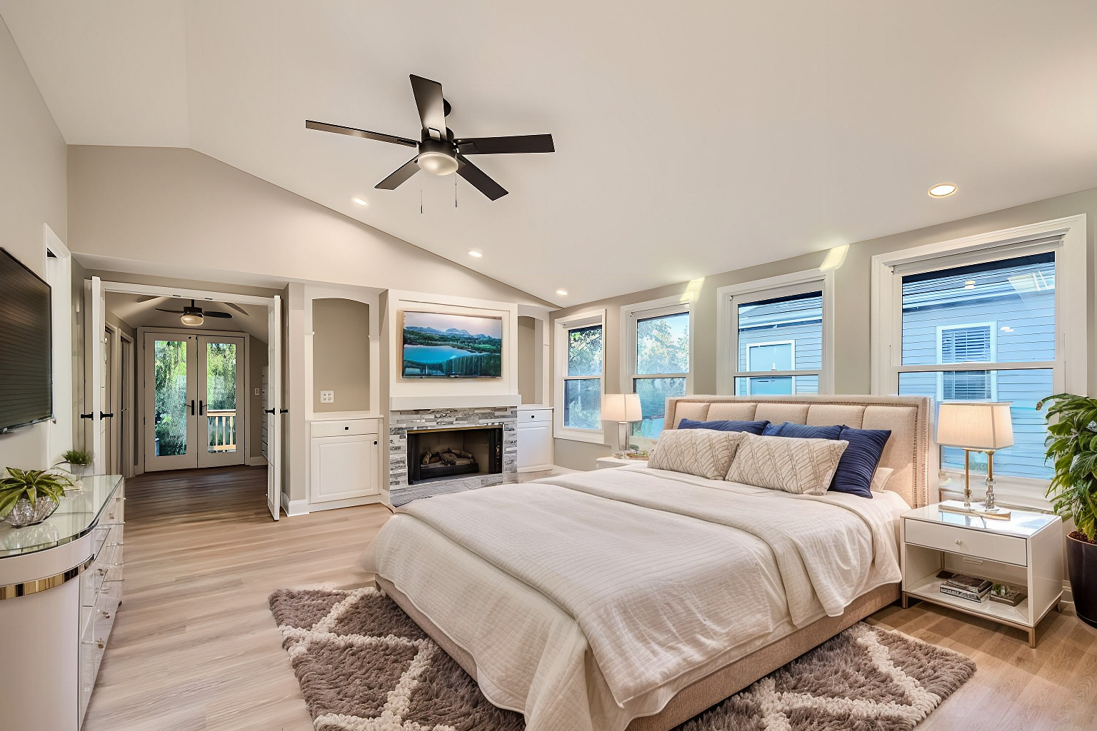 386 Blackhawk Road Riverside, IL 60546 - Photo 19 of 44 a spacious bedroom with a large bed a flat tv screen and a fireplace