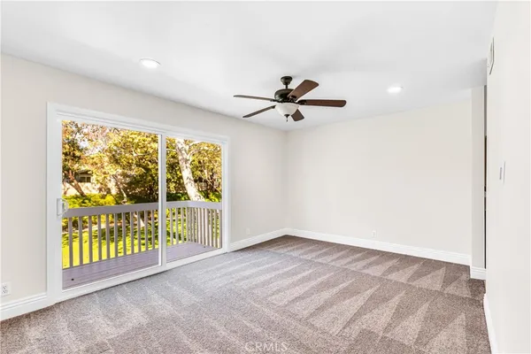 an empty room with a window and ceiling fan