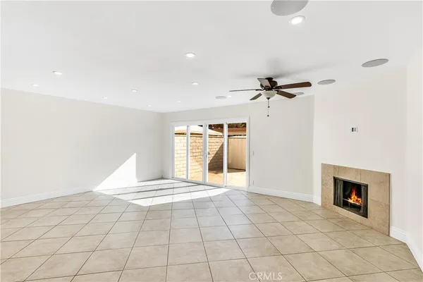 a view of an empty room with a fireplace and a window