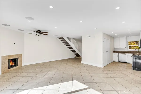 a white kitchen with granite countertop stainless steel appliances and white cabinets