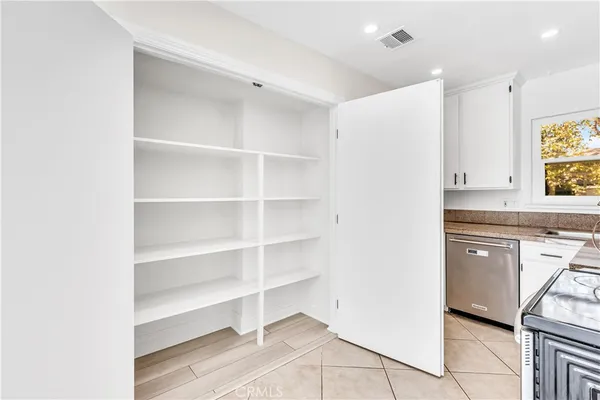 wooden floor in an empty room with a kitchen