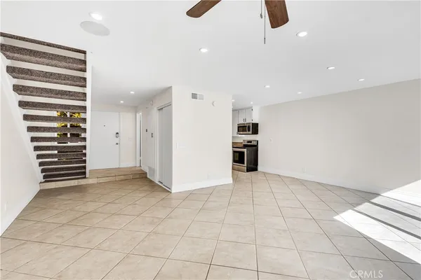 an empty room with a window and a fan