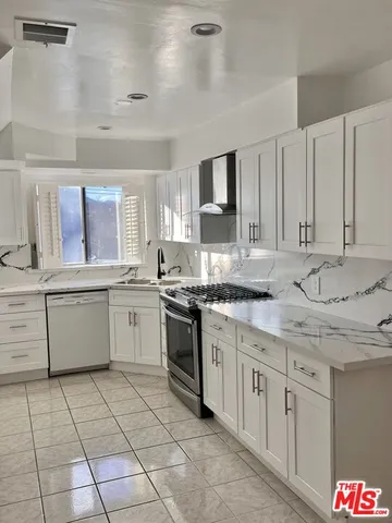 a kitchen with a sink window and cabinets