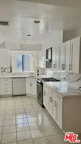 a kitchen with stainless steel appliances a refrigerator sink and cabinets