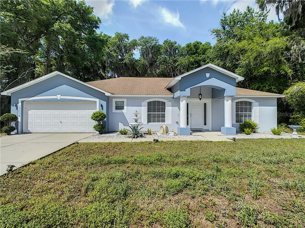 13034 Southwest 43rd Ave Road Ocala, FL 34473 - Photo 1 of 1 a front view of a house with a yard and garage