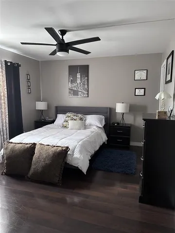a bedroom with a bed and a ceiling fan