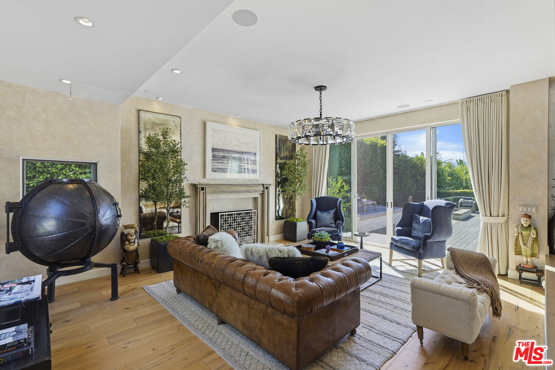 3631 Serra Road Malibu, CA 90265 - Photo 15 of 74 a living room with furniture a chandelier and a large window