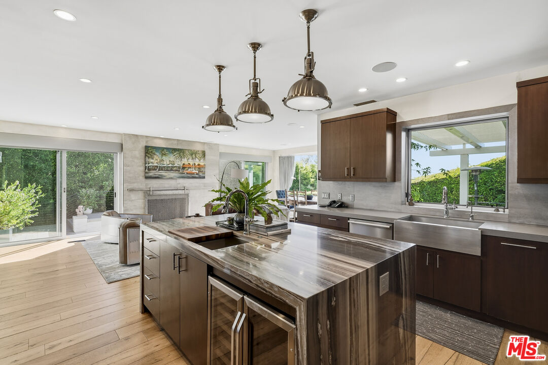 3631 Serra Road Malibu, CA 90265 - Photo 23 of 74 a kitchen with stainless steel appliances granite countertop a sink a stove and a wooden floors