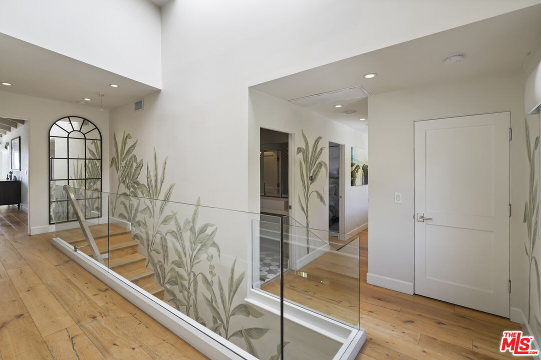 3631 Serra Road Malibu, CA 90265 - Photo 26 of 74 a view of a hallway with wooden floor and a living room