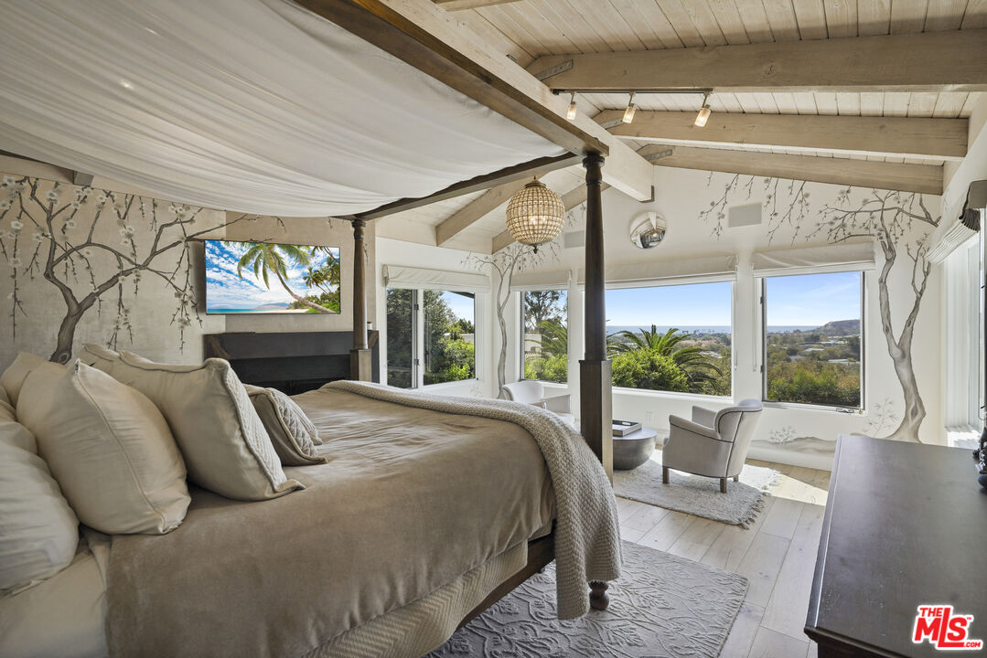 3631 Serra Road Malibu, CA 90265 - Photo 34 of 74 a bed sitting in a bedroom next to a window