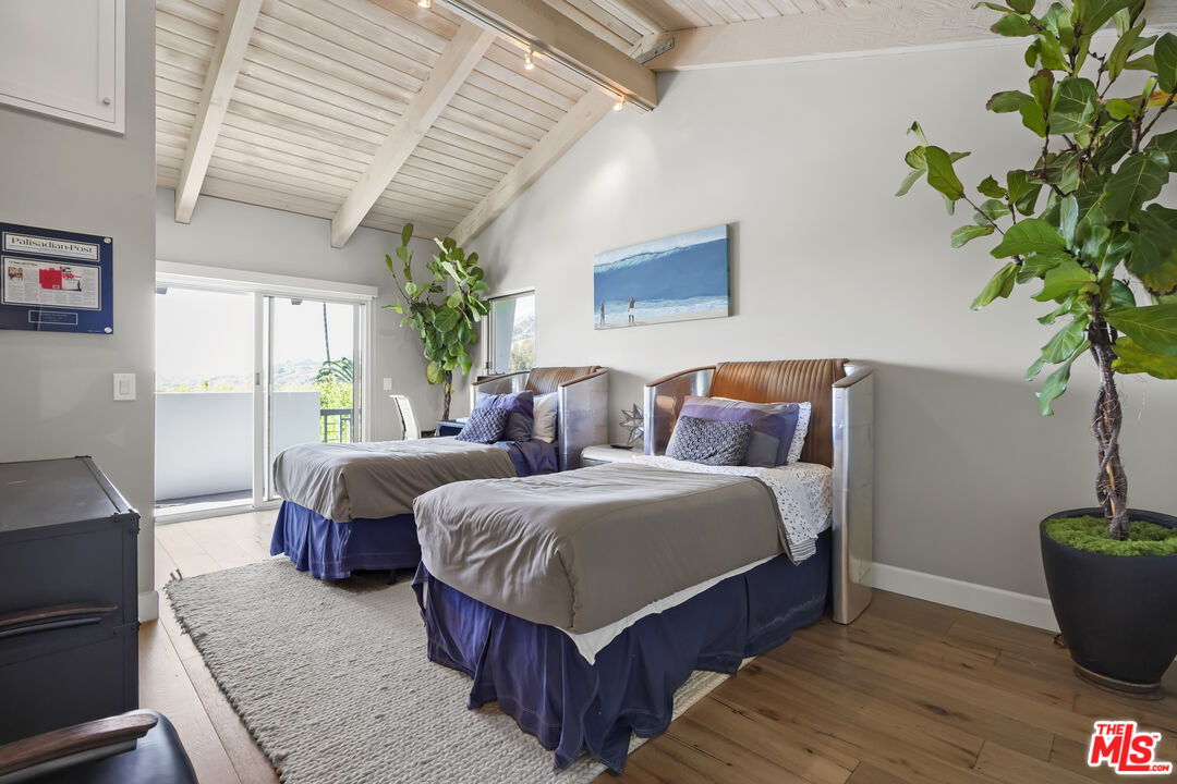 3631 Serra Road Malibu, CA 90265 - Photo 43 of 74 a spacious bedroom with a bed and a potted plant