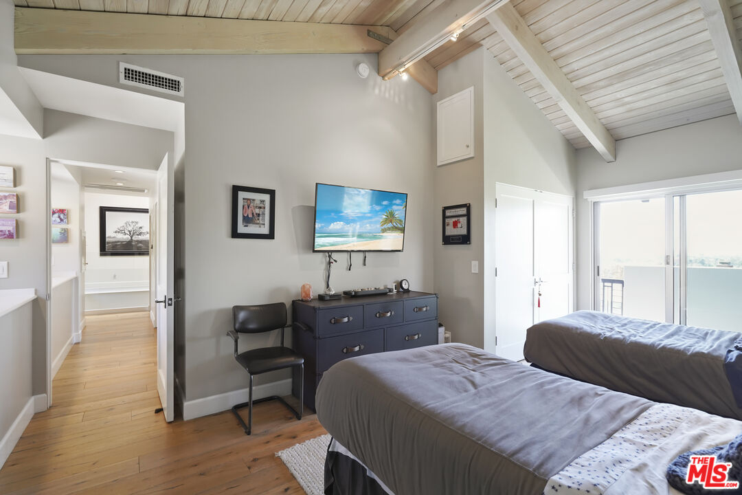 3631 Serra Road Malibu, CA 90265 - Photo 44 of 74 a bedroom with a bed and wooden floor