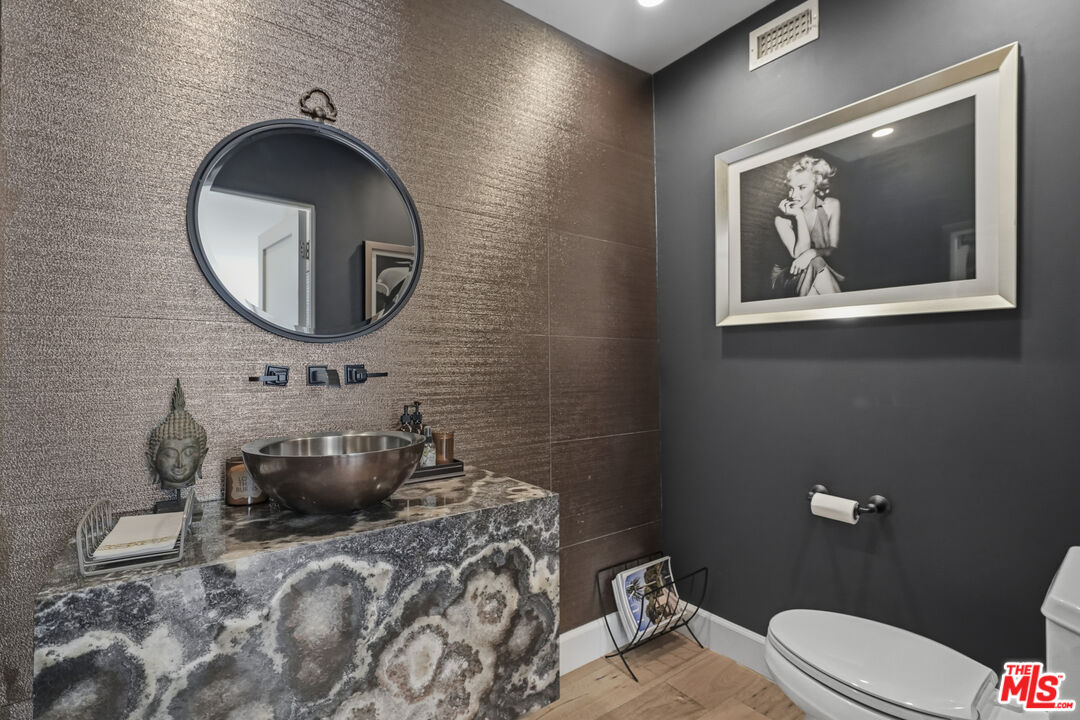3631 Serra Road Malibu, CA 90265 - Photo 46 of 74 a bathroom with a toilet a sink and mirror