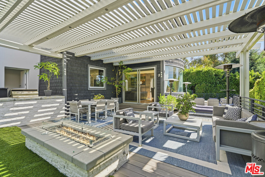 3631 Serra Road Malibu, CA 90265 - Photo 47 of 74 a view of a patio with couches table and chairs and potted plants