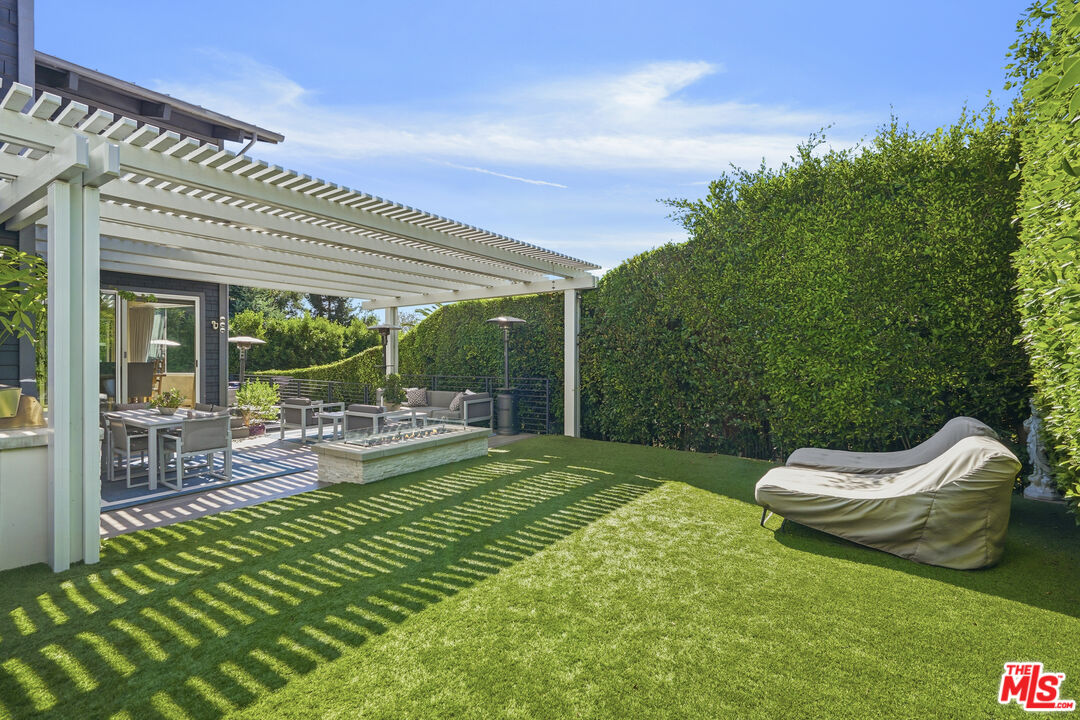 3631 Serra Road Malibu, CA 90265 - Photo 48 of 74 a view of a chair and tables in the patio in front of the house