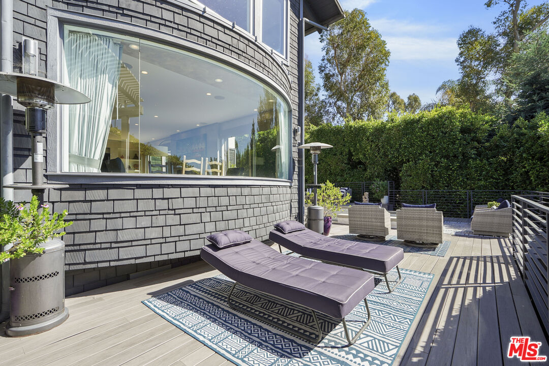 3631 Serra Road Malibu, CA 90265 - Photo 53 of 74 a view of a patio with couches table and chairs and potted plants