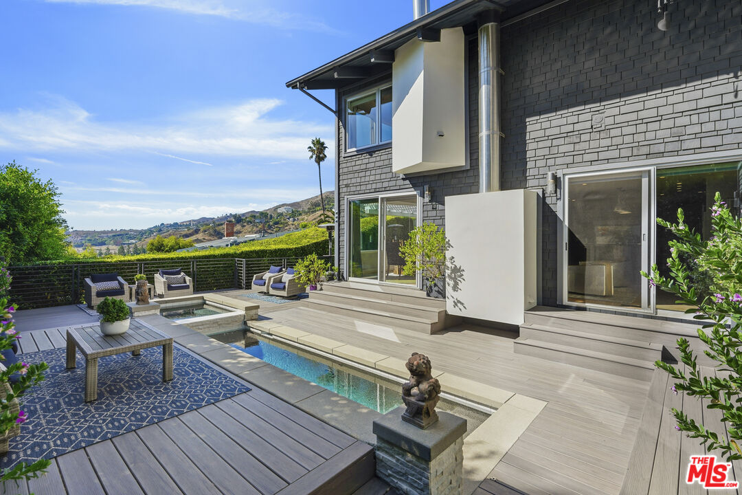 3631 Serra Road Malibu, CA 90265 - Photo 57 of 74 a view of a chairs and table on the wooden deck