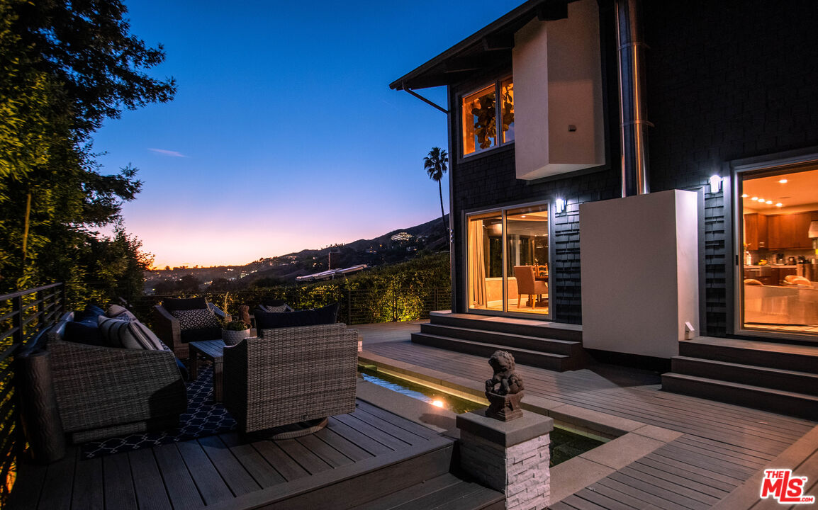 3631 Serra Road Malibu, CA 90265 - Photo 70 of 74 a view of a balcony with two chairs and a potted plant