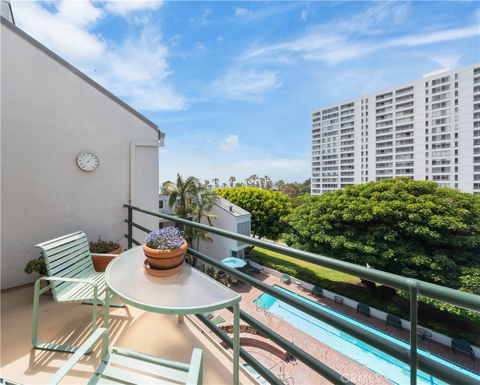 a view of a balcony with dining table and chairs