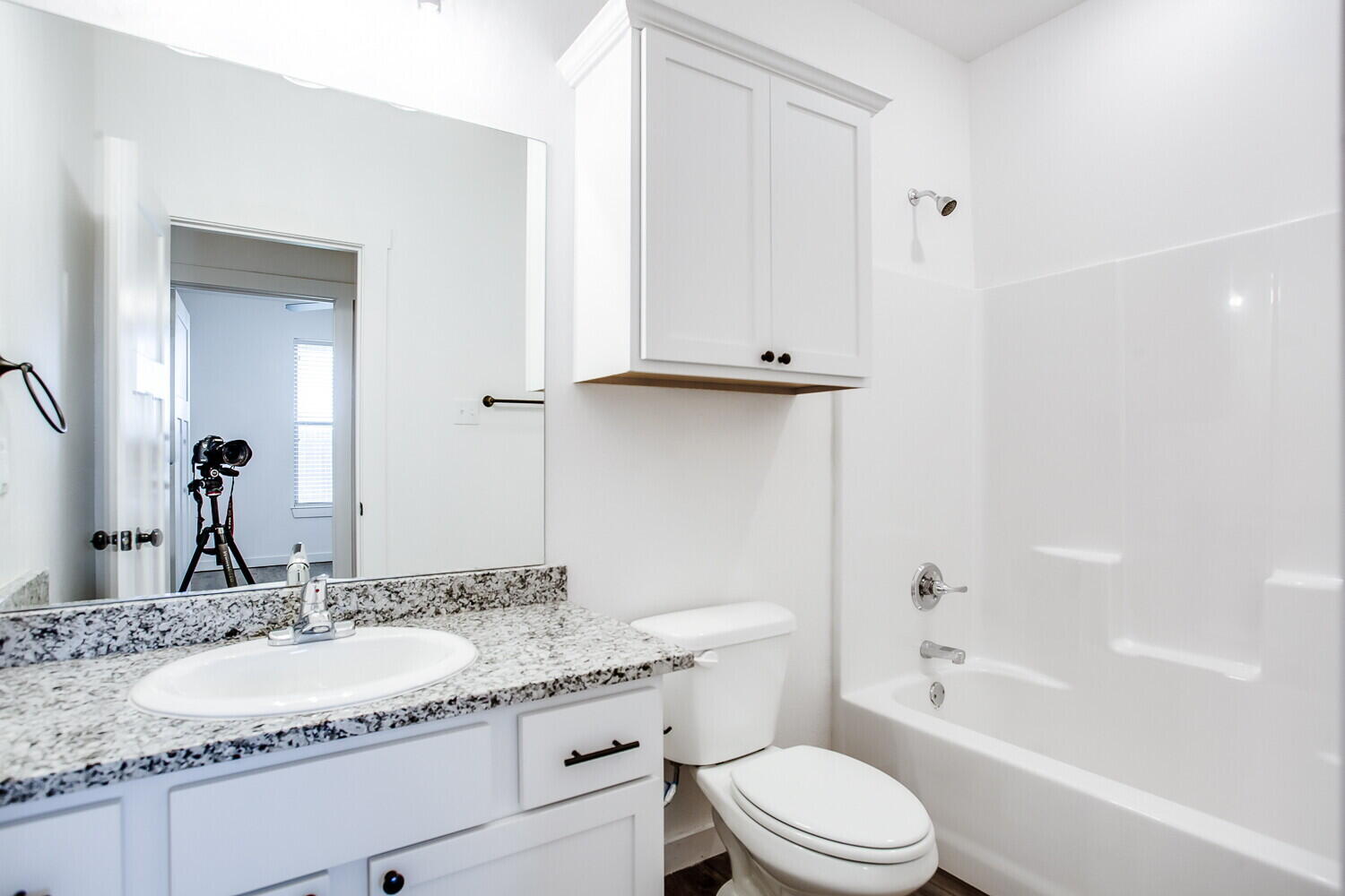 2539 138th Street Lubbock, TX 79423 - Photo 14 of 15 a bathroom with a granite countertop sink toilet mirror and bathtub