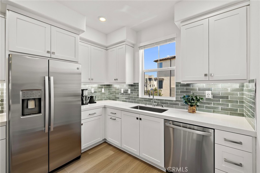 61 Wheelbarrow Road Rancho Mission Viejo, CA 92694 - Photo 5 of 74 a kitchen with a sink stainless steel appliances and white cabinets