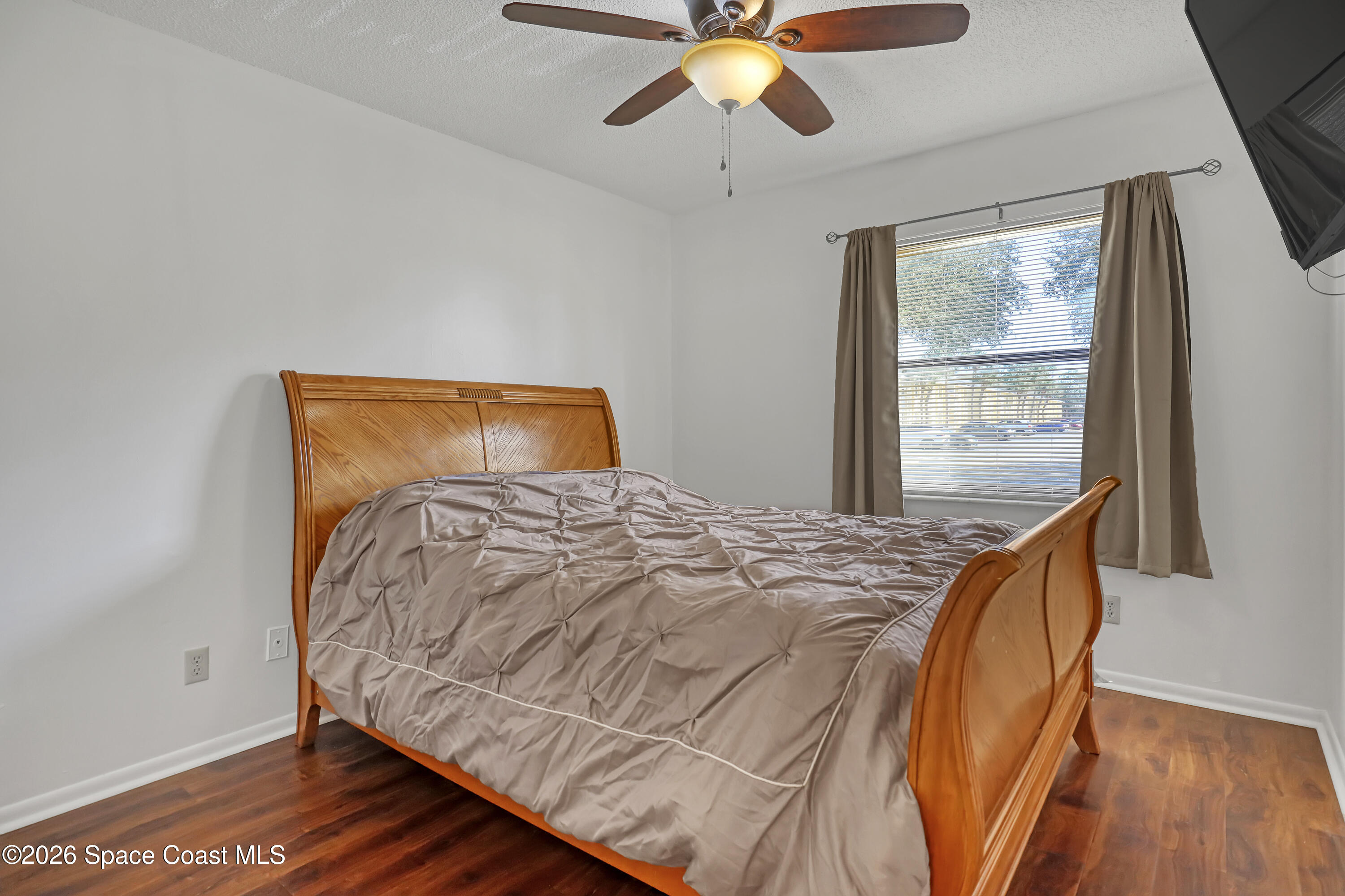 588 North Wickham Road, Unit 51 Melbourne, FL 32935 - Photo 16 of 27 a bedroom with a bed and wooden floor