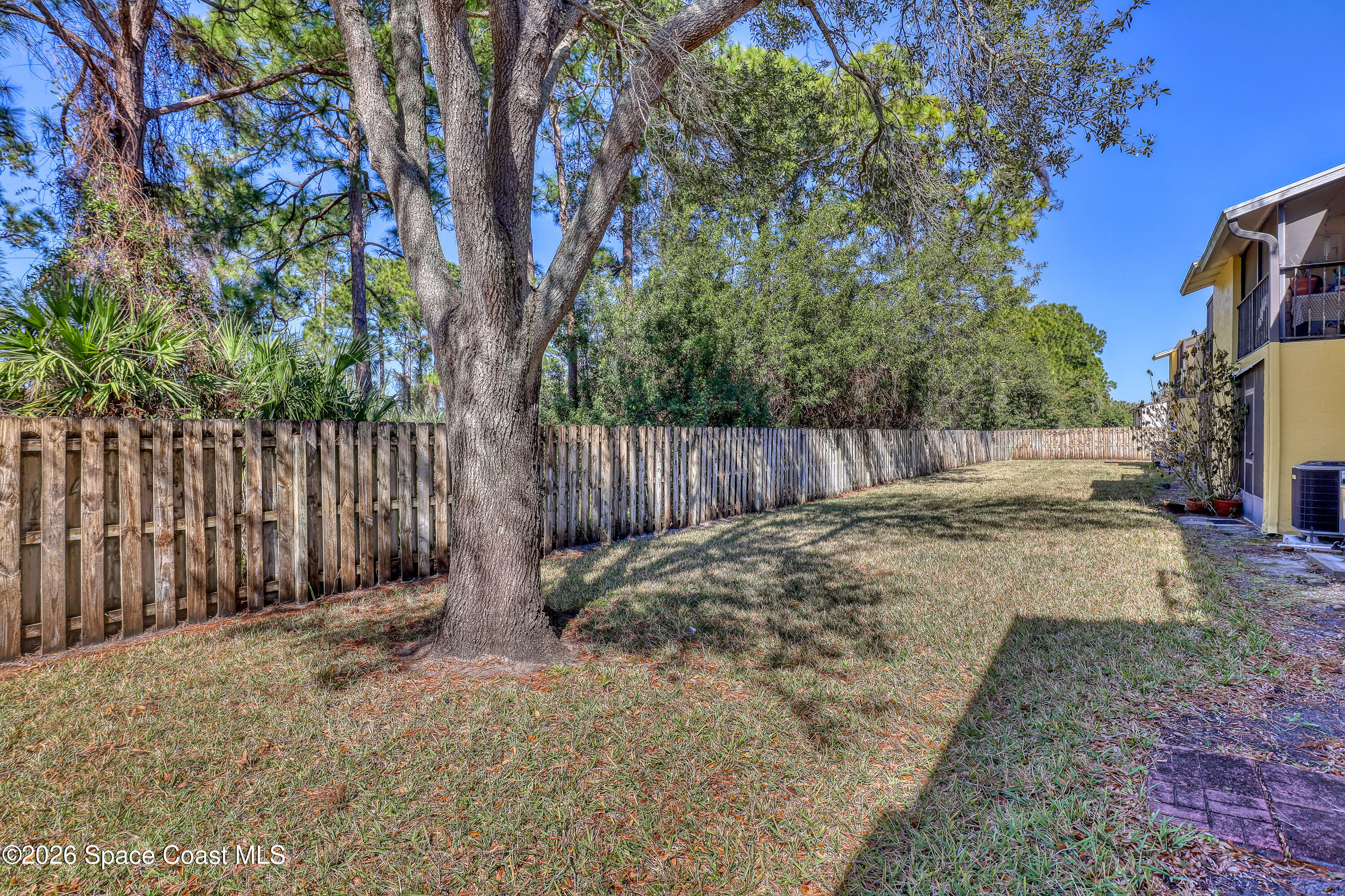 588 North Wickham Road, Unit 51 Melbourne, FL 32935 - Photo 25 of 27 a backyard of a house with a small yard and wooden fence