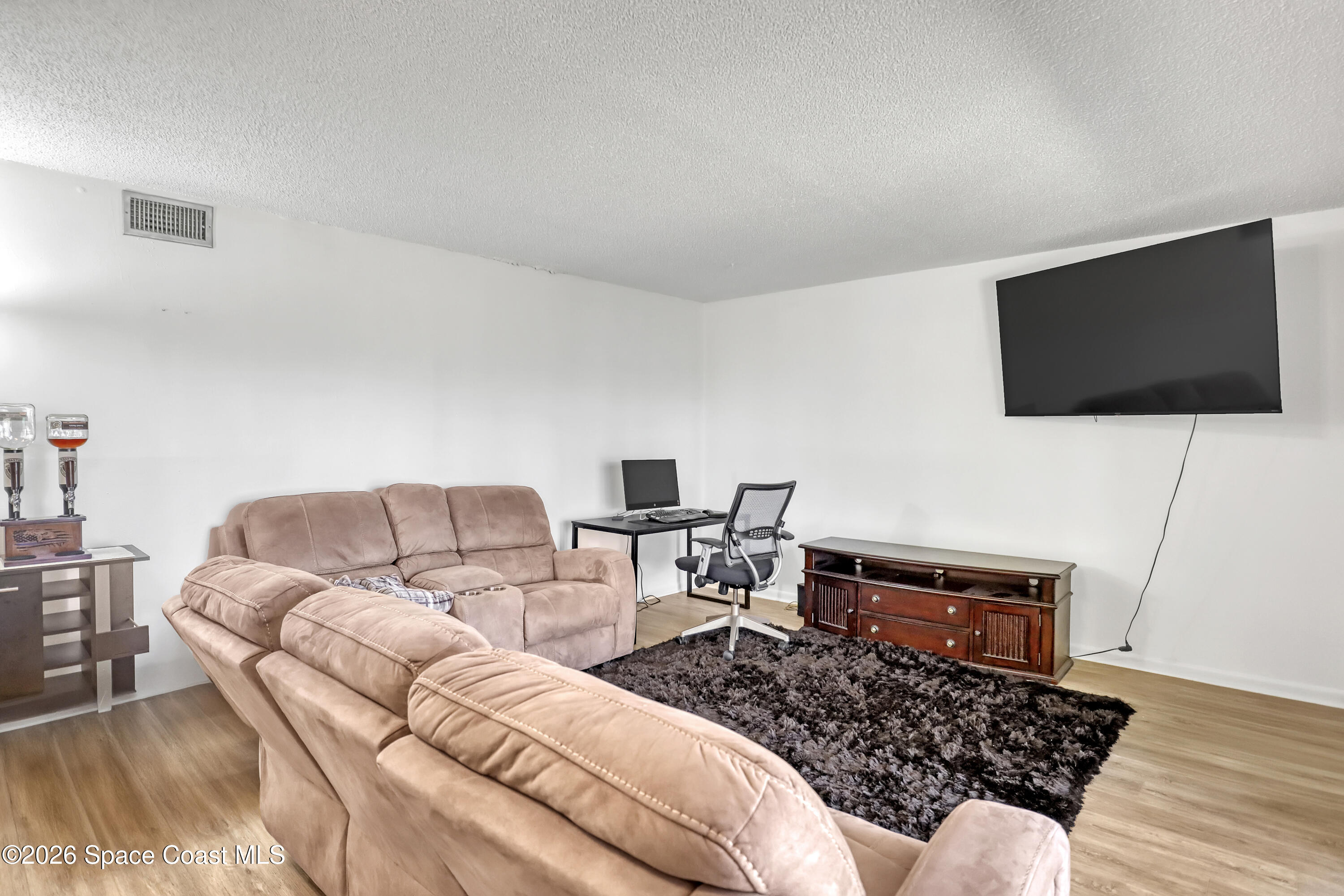 588 North Wickham Road, Unit 51 Melbourne, FL 32935 - Photo 6 of 27 a living room with furniture and a flat screen tv