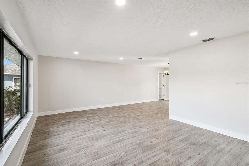 5248 Frost Road Spring Hill, FL 34606 - Photo 11 of 70 a view of an empty room with wooden floor and a window
