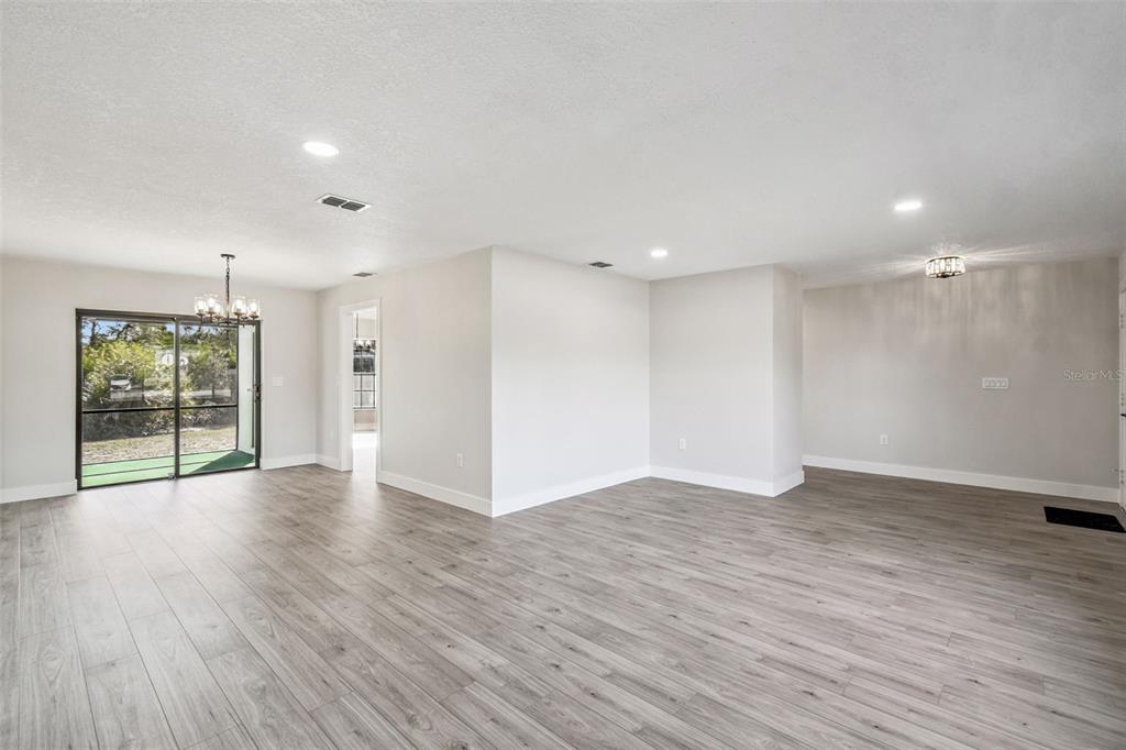 5248 Frost Road Spring Hill, FL 34606 - Photo 12 of 70 a view of an empty room with wooden floor and a window