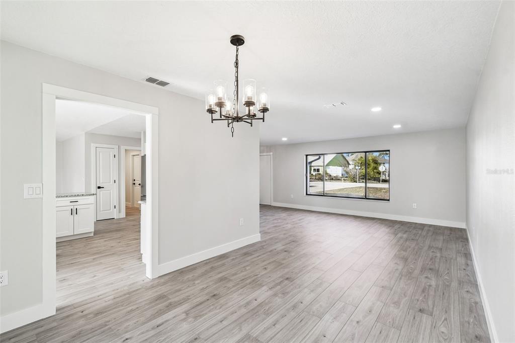 5248 Frost Road Spring Hill, FL 34606 - Photo 16 of 70 a view of a hallway with wooden floor and chandelier