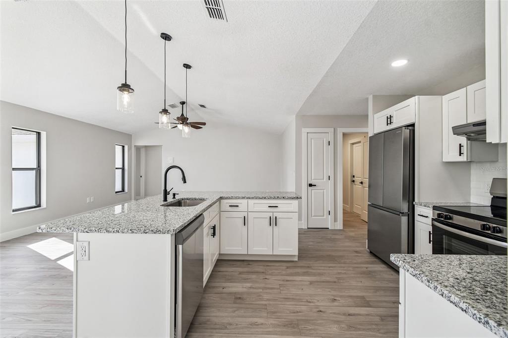 5248 Frost Road Spring Hill, FL 34606 - Photo 26 of 70 a kitchen with stainless steel appliances granite countertop a sink stove and refrigerator