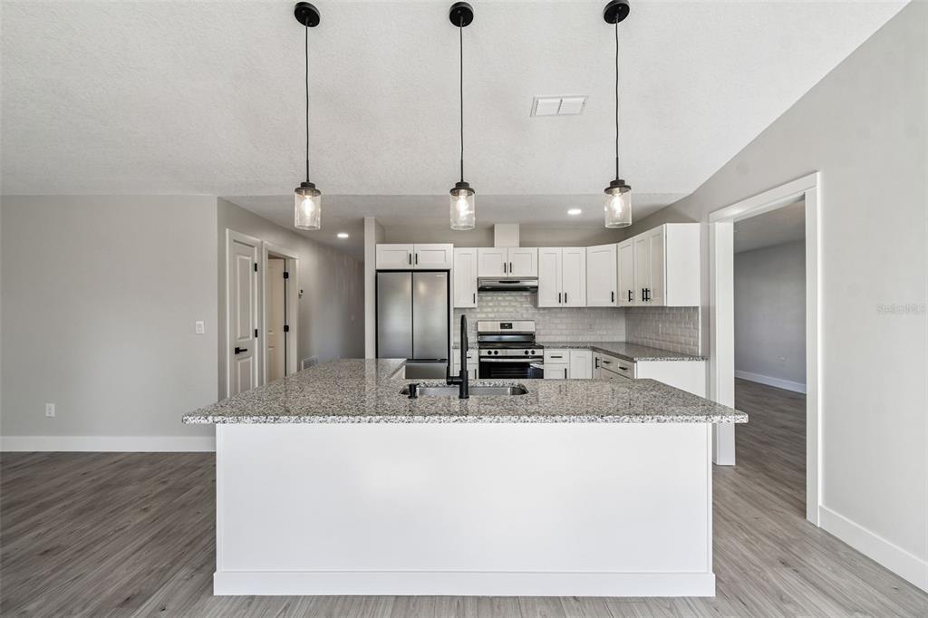 5248 Frost Road Spring Hill, FL 34606 - Photo 28 of 70 a kitchen with kitchen island a counter top space a sink and appliances