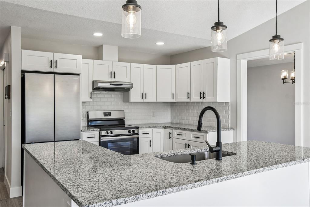 5248 Frost Road Spring Hill, FL 34606 - Photo 30 of 70 a kitchen with stainless steel appliances granite countertop a sink a stove a refrigerator and cabinets