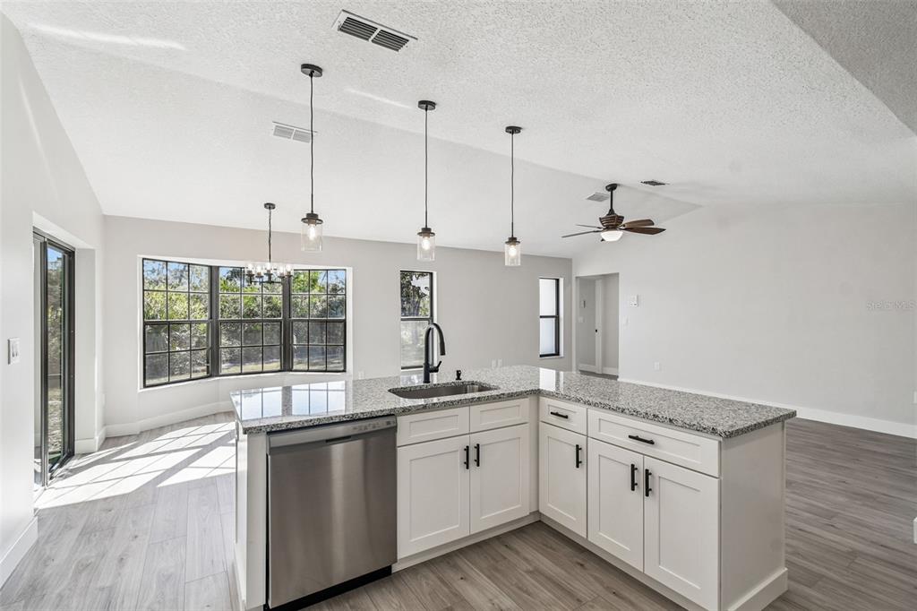 5248 Frost Road Spring Hill, FL 34606 - Photo 35 of 70 a kitchen with stainless steel appliances granite countertop a sink a stove and a wooden floor