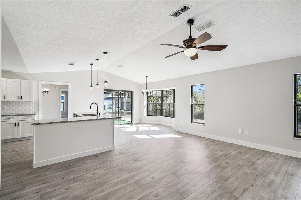 5248 Frost Road Spring Hill, FL 34606 - Photo 42 of 70 a open kitchen with granite countertop a stove top oven a sink with white cabinets and wooden floor