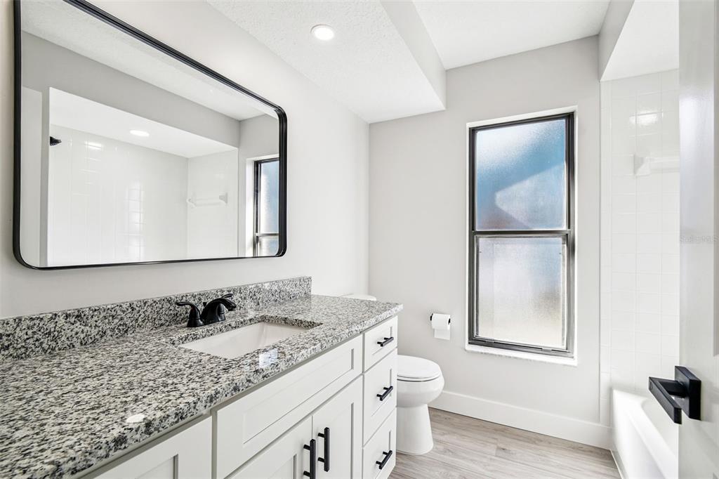 5248 Frost Road Spring Hill, FL 34606 - Photo 49 of 70 a bathroom with a granite countertop sink and a mirror