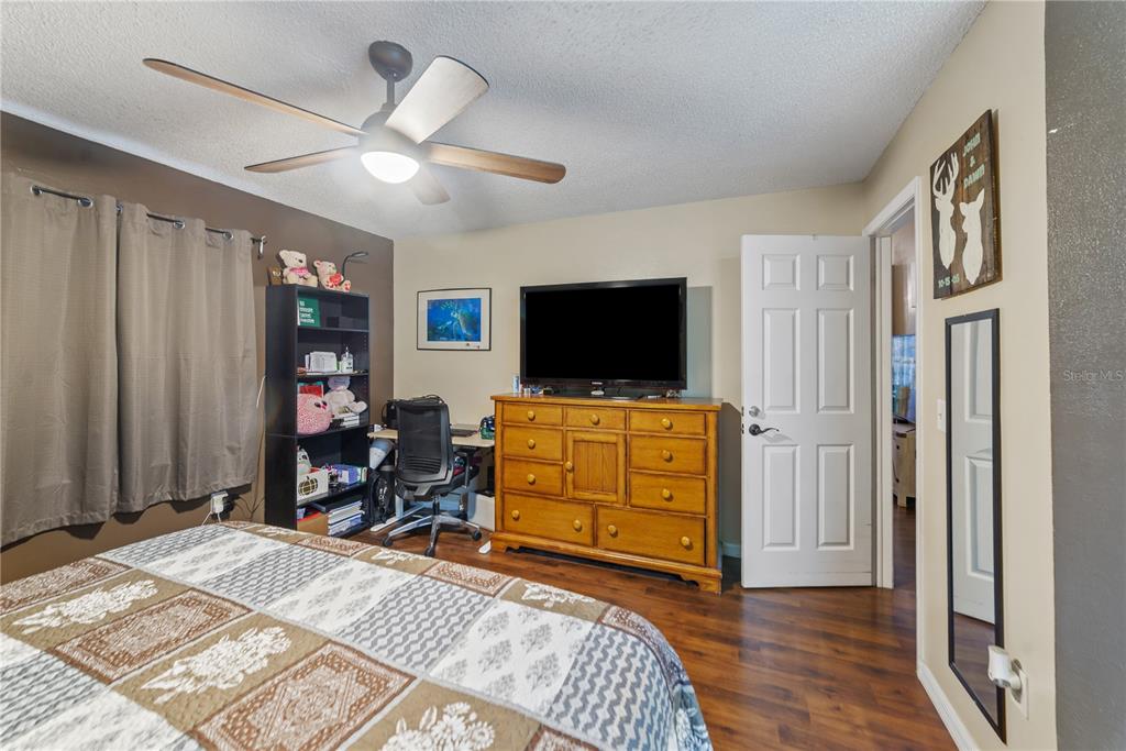 8715 Huntsman Lane Port Richey, FL 34668 - Photo 24 of 54 a bed room with a bed and a flat tv screen on a dresser