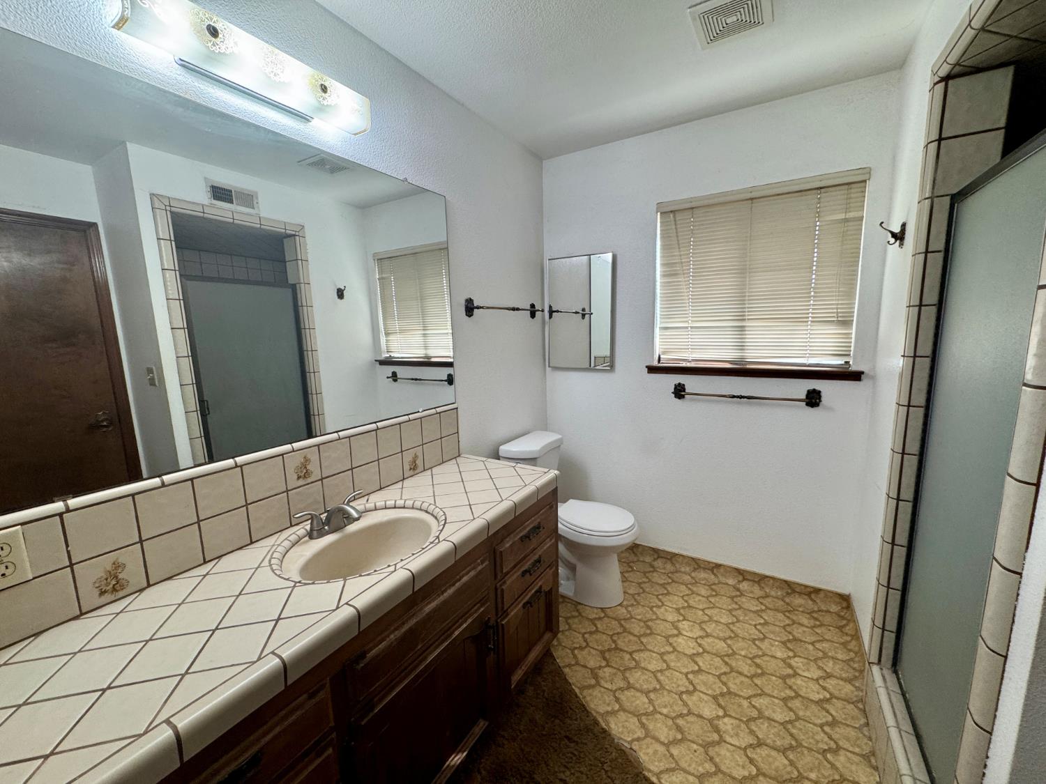 17617 West Belmont Avenue Kerman, CA 93630 - Photo 16 of 25 a bathroom with a sink a toilet and mirror