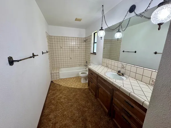 a bathroom with a tub sink and mirror