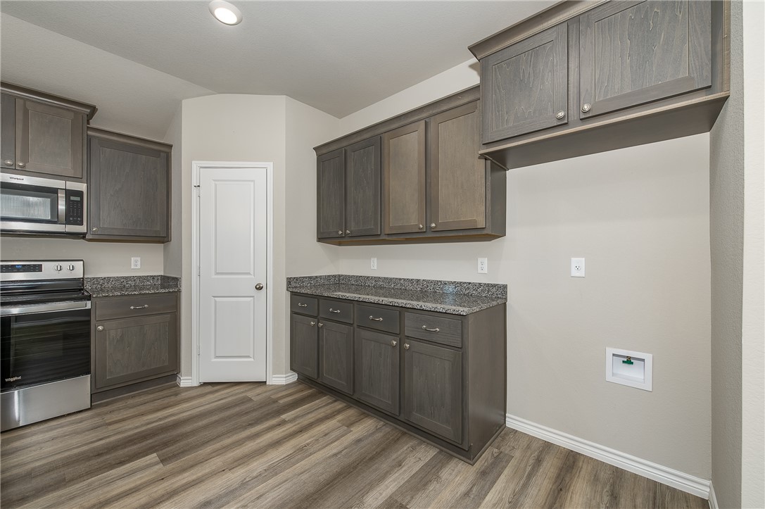 2166 Chief Street Bryan, TX 77807 - Photo 8 of 18 a kitchen with stainless steel appliances granite countertop a refrigerator a stove top oven and sink