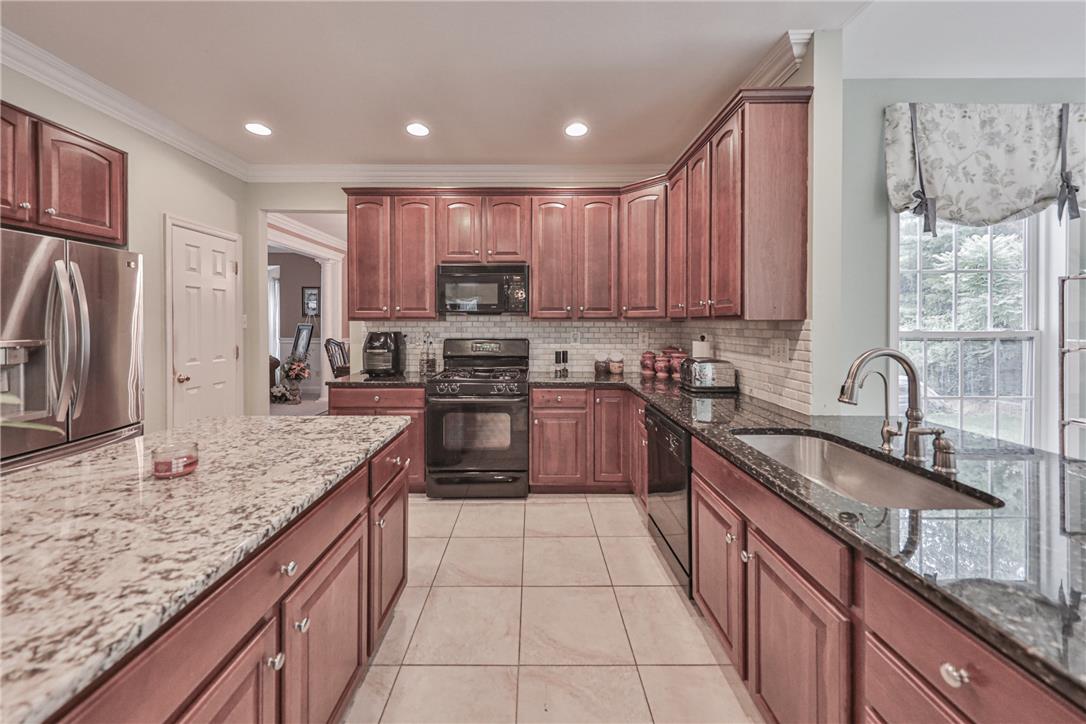 138 Clover Hollow Road Easton, PA 18045 - Photo 23 of 95 A well-appointed kitchen features rich wood cabinetry, granite countertops, and modern appliances, creating an inviting culinary space.