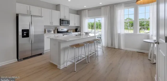 a kitchen with stainless steel appliances granite countertop a hardwood floor sink stove and refrigerator