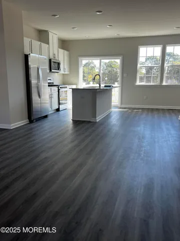 a view of kitchen with refrigerator and window