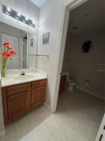 a bathroom with a double vanity sink a mirror and a toilet
