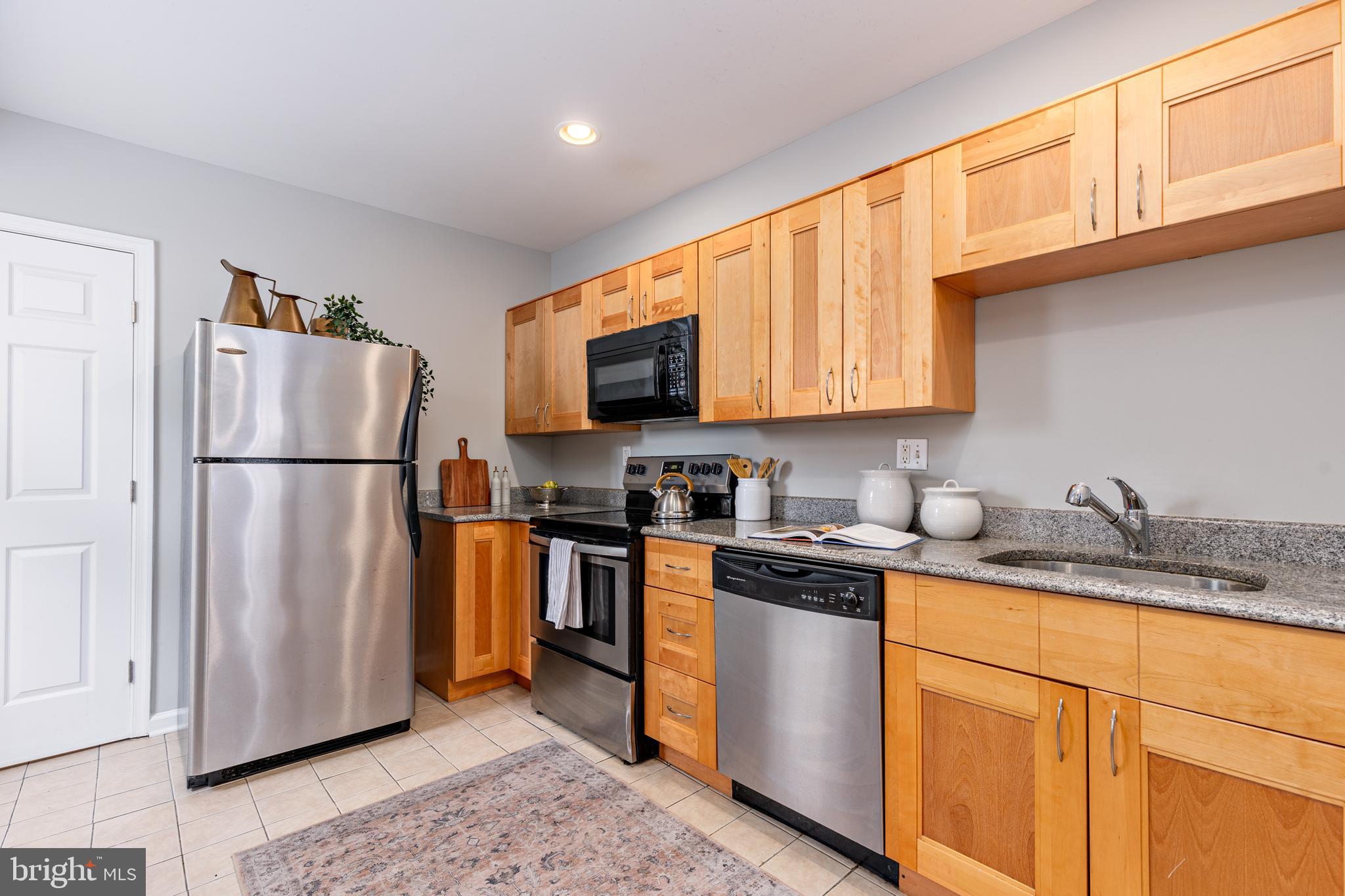 305 South Castle Street Baltimore, MD 21231 - Photo 6 of 28 a kitchen with stainless steel appliances granite countertop a refrigerator stove a sink and a microwave