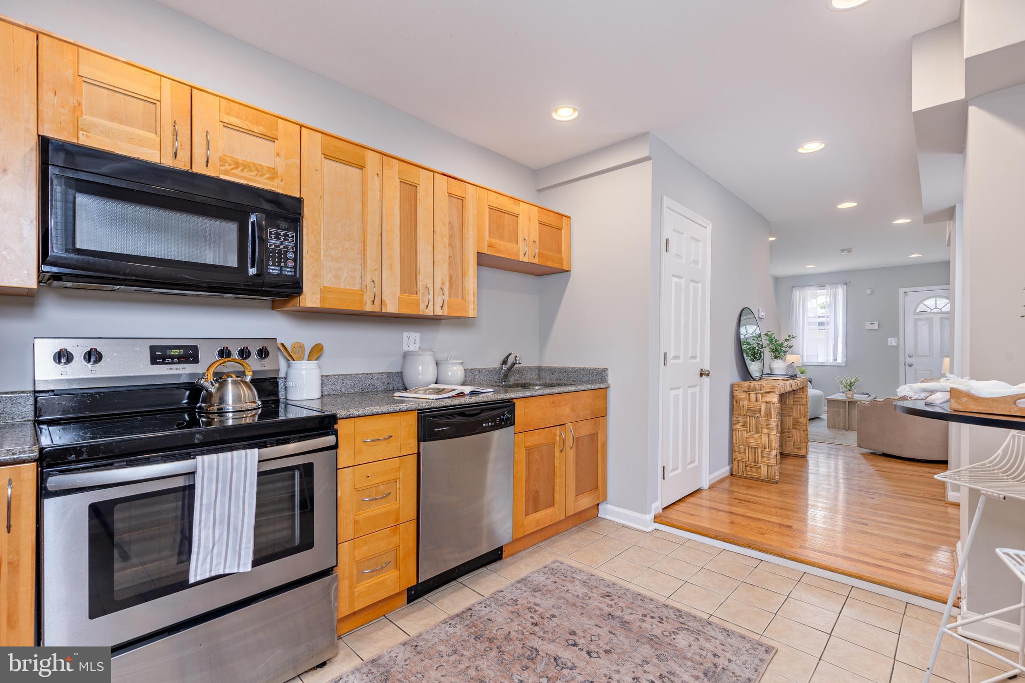 305 South Castle Street Baltimore, MD 21231 - Photo 27 of 28 a kitchen with stainless steel appliances granite countertop a stove a sink and a microwave