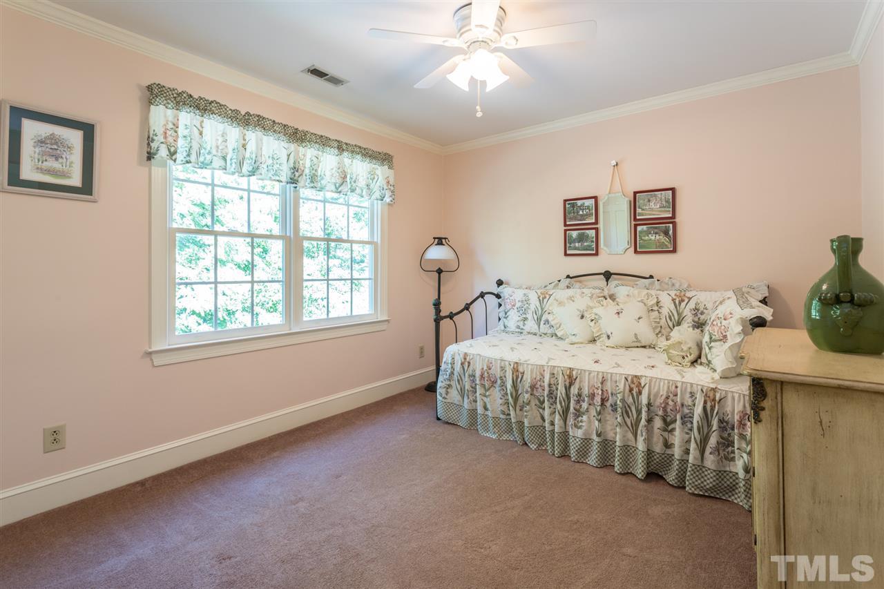 1812 Albacore Lane Raleigh, NC 27612 - Photo 14 of 30 a bedroom with a bed and a chandelier