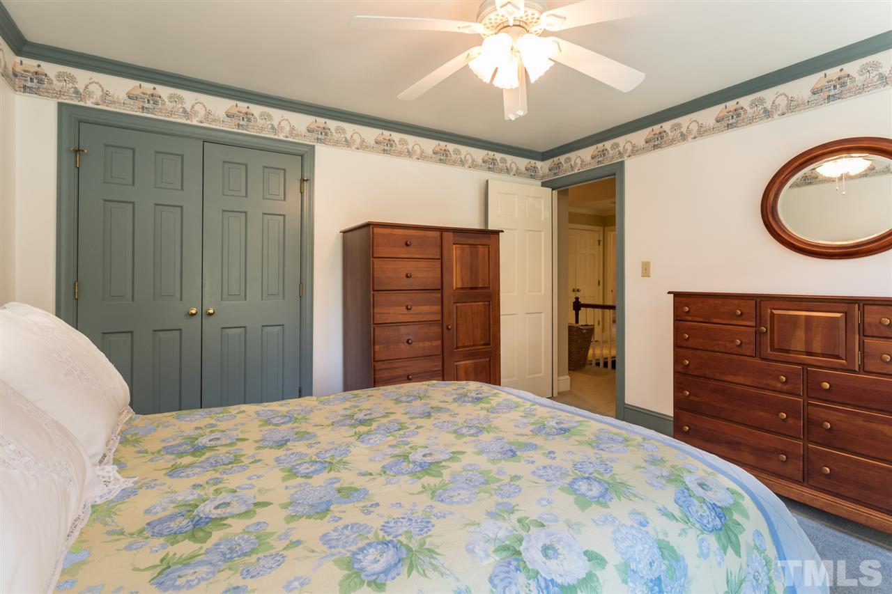 1812 Albacore Lane Raleigh, NC 27612 - Photo 18 of 30 a bedroom with a bed and a chandelier